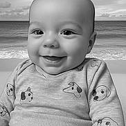 Ezio a rejoint le concours — aidez-le/la à gagner de superbes lots ! baby, smiling, infant, sweater, dog_pattern, portrait, black_and_white, ocean, beach, background, cute, child, happy, face, clothing, seaside, calm, young, sitting, closeup