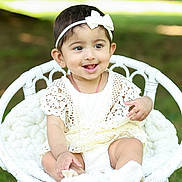 Thryambika is registered to the contest to win money with this photo: baby, child, cute, grass, greenery, happy, headband, infant, lace_dress, nature, outdoor, playful, portrait, sitting, smiling, soft_blanket, sunlight, white_bow, white_clothing, wicker_chair
