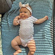 Scar joined the competition — help win amazing prizes! baby, infant, headband, bow, onesie, textile, blanket, knitted, blue, pink, tongue_out, playful, cute, chubby, skin, couch, light_and_shadow, indoor, smiling, person