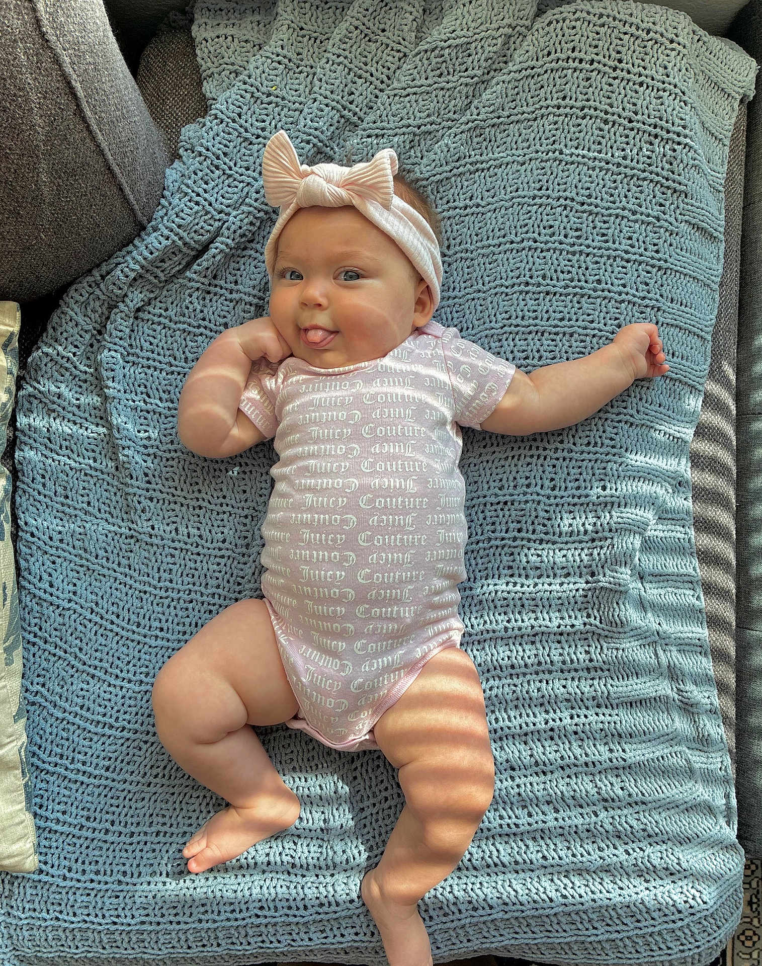 Scar joined the competition — help win amazing prizes! baby, infant, headband, bow, onesie, textile, blanket, knitted, blue, pink, tongue_out, playful, cute, chubby, skin, couch, light_and_shadow, indoor, smiling, person
