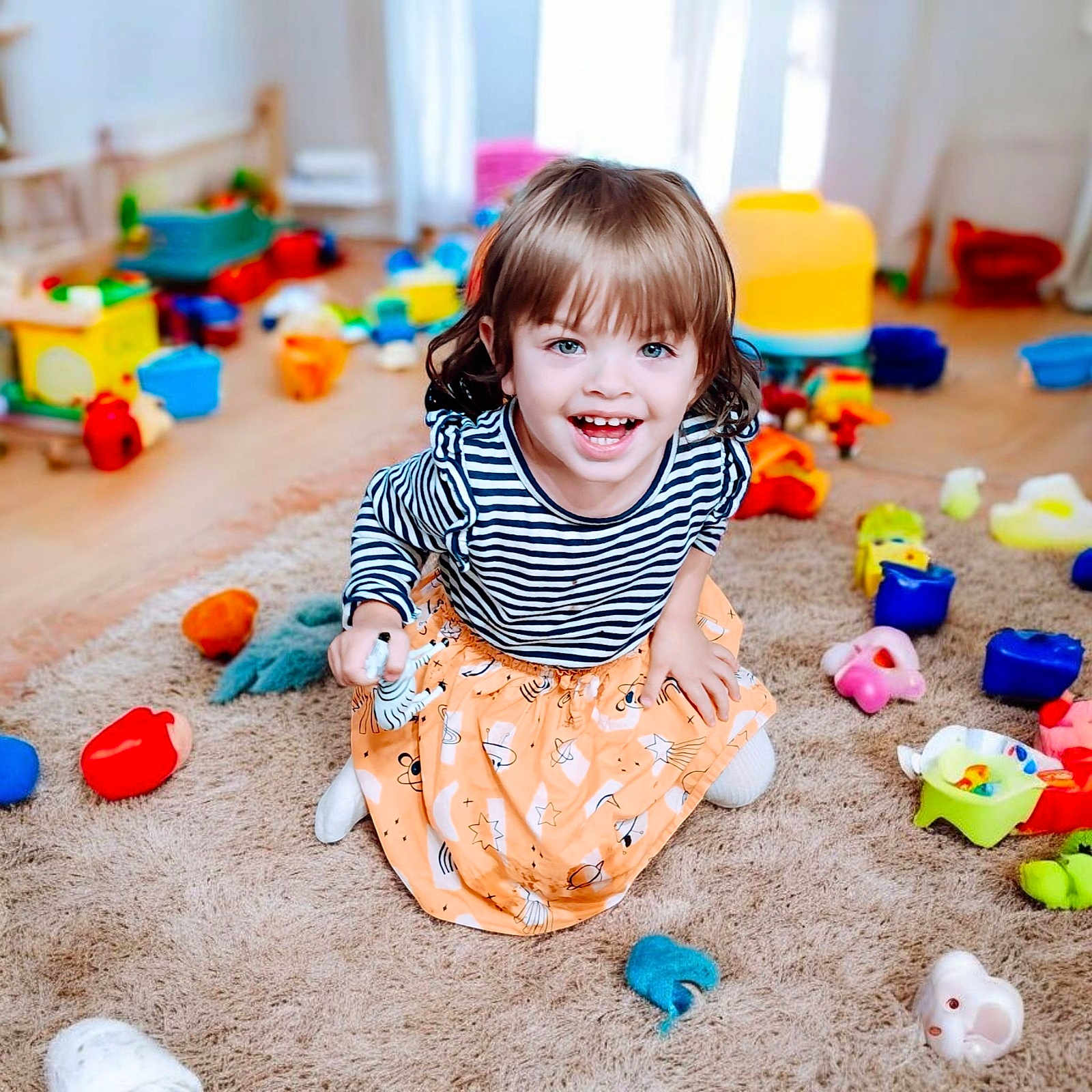 Rhielly is registered to the contest to win money with this photo: bright, carpet, child, colorful, cute, fun, happy, indoor, joy, kid, orange_skirt, person, play, playful, room, smiling, striped_shirt, toddler, toys, young