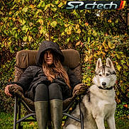 Iris a rejoint le concours — aidez-le/la à gagner de superbes lots ! woman, dog, husky, chair, outdoor, grass, foliage, greenery, autumn, jacket, boots, pet, animal, nature, relaxation, leisure, portrait, seated, text_overlay, advertisement