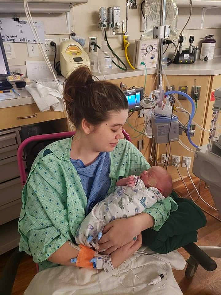 Bradley is registered to the contest to win money with this photo: baby, baby_products, baby_toddler_clothing, cabinetry, chest_of_drawers, comfort, drawer, hand, health_care, hospital, hospital_bed, human_body, lap, machine, medical, medical_equipment, medical_procedure, patient, person, room