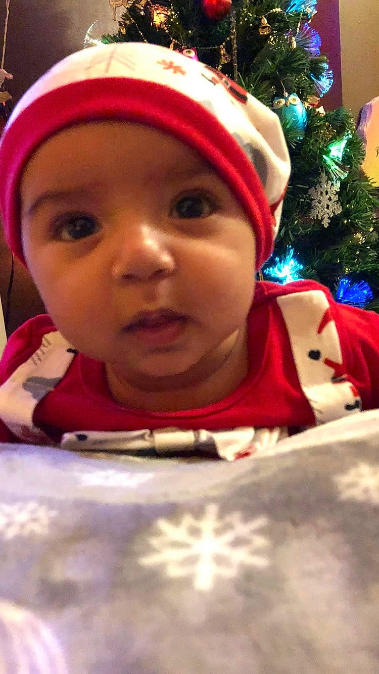 Asher joined the competition — help win amazing prizes! baby, cap, cheek, child, chin, christmas, christmas_tree, event, eye, face, facial_expression, fun, happy, headwear, holiday, iris, lip, mouth, nose, person
