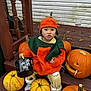 child, toddler, pumpkin_costume, halloween, pumpkins, bucket, orange, green, wooden_steps, fall, festive, cute, outdoor, seasonal, costume, decorations, playful, expression, clothing, holiday