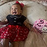 Nazaria is registered to the contest to win money with this photo: baby, infant, smiling, red_dress, headband, pillow, bed, blanket, cute, milestone, two_months, happy, child, indoors, person, footwear, socks, celebration, portrait, lying_down