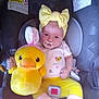 baby, car_seat, child, child_seat, comfort, cute, face, indoor, infant, pacifier, person, plush_toy, sitting, smile, soft_toy, stuffed_animal, toy, white_socks, yellow_headband, yellow_pants