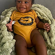 Kingston joined the competition — help win amazing prizes! baby, child, smiling, onesie, blanket, cozy, indoor, happy, cute, infant, drool, face, portrait, sitting, dark_skin, curly_hair, clothing, soft_texture, closeup, person