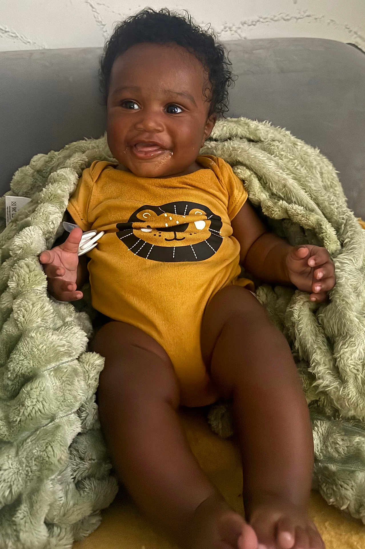 Kingston joined the competition — help win amazing prizes! baby, child, smiling, onesie, blanket, cozy, indoor, happy, cute, infant, drool, face, portrait, sitting, dark_skin, curly_hair, clothing, soft_texture, closeup, person