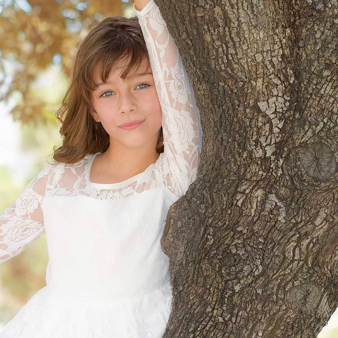 Sophya is registered to the contest to win money with this photo: beauty, brown_hair, child, child_model, dress, eye, hair, hairstyle, lace, lady, lip, long_hair, outerwear, person, photo_shoot, photography, skin, smile, tree, trunk