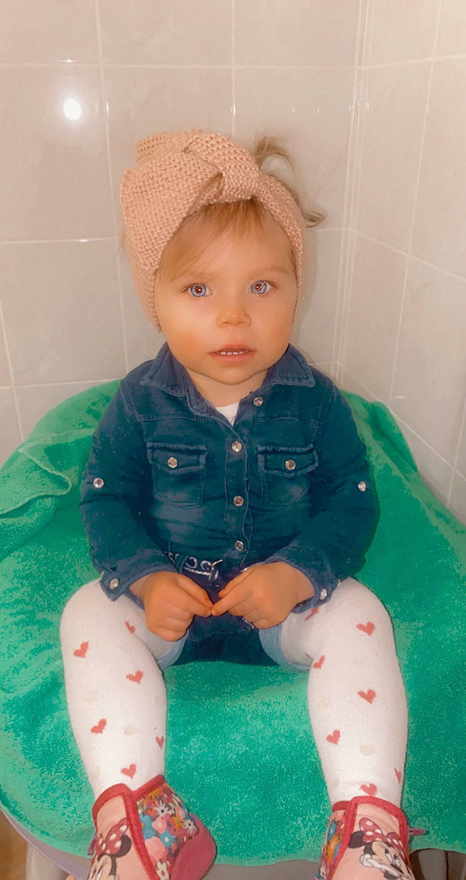 Marie participe au concours pour gagner de l'argent avec cette photo : baby, baby_toddler_clothing, bathroom, bonnet, cheek, child, costume_accessory, overall, person, plumbing, sitting, skin, sock, tile, toddler