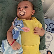 Miran a rejoint le concours — aidez-le/la à gagner de superbes lots ! baby, pacifier, plush_toy, yellow_clothing, bed, pillow, blanket, infant, child, cute, sleepwear, soft_toy, relaxing, indoors, resting, hand, face, head, lying_down, expression