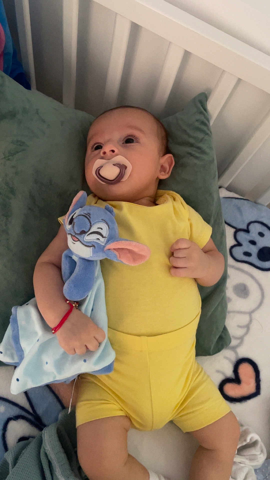 Miran a rejoint le concours — aidez-le/la à gagner de superbes lots ! baby, pacifier, plush_toy, yellow_clothing, bed, pillow, blanket, infant, child, cute, sleepwear, soft_toy, relaxing, indoors, resting, hand, face, head, lying_down, expression