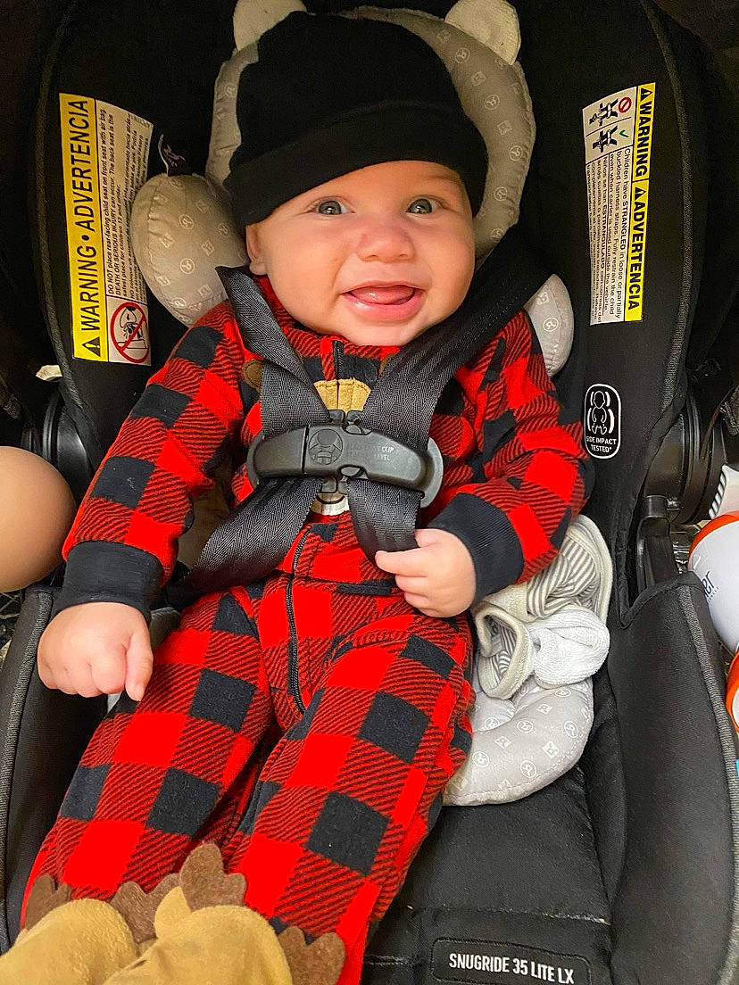 Jonahz is registered to the contest to win money with this photo: baby, baby_carriage, baby_products, baby_toddler_clothing, cap, car_seat, child, comfort, eye, headwear, outerwear, pattern, person, plaid, product, sitting, sleeve, smile, tartan, textile