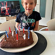 Chrys a rejoint le concours — aidez-le/la à gagner de superbes lots ! child, boy, birthday_cake, candles, smoke, table, plate, indoor, television, chair, tshirt, celebration, home, food, happy, smiling, cake, furniture, person, event