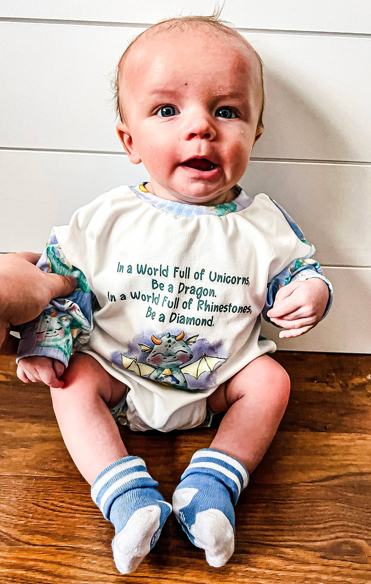 Ryker joined the competition — help win amazing prizes! baby, baby_toddler_clothing, cheek, child, finger, flash_photography, floor, flooring, happy, hardwood, pattern, person, product, sitting, skin, sleeve, t_shirt, toddler, white, wood