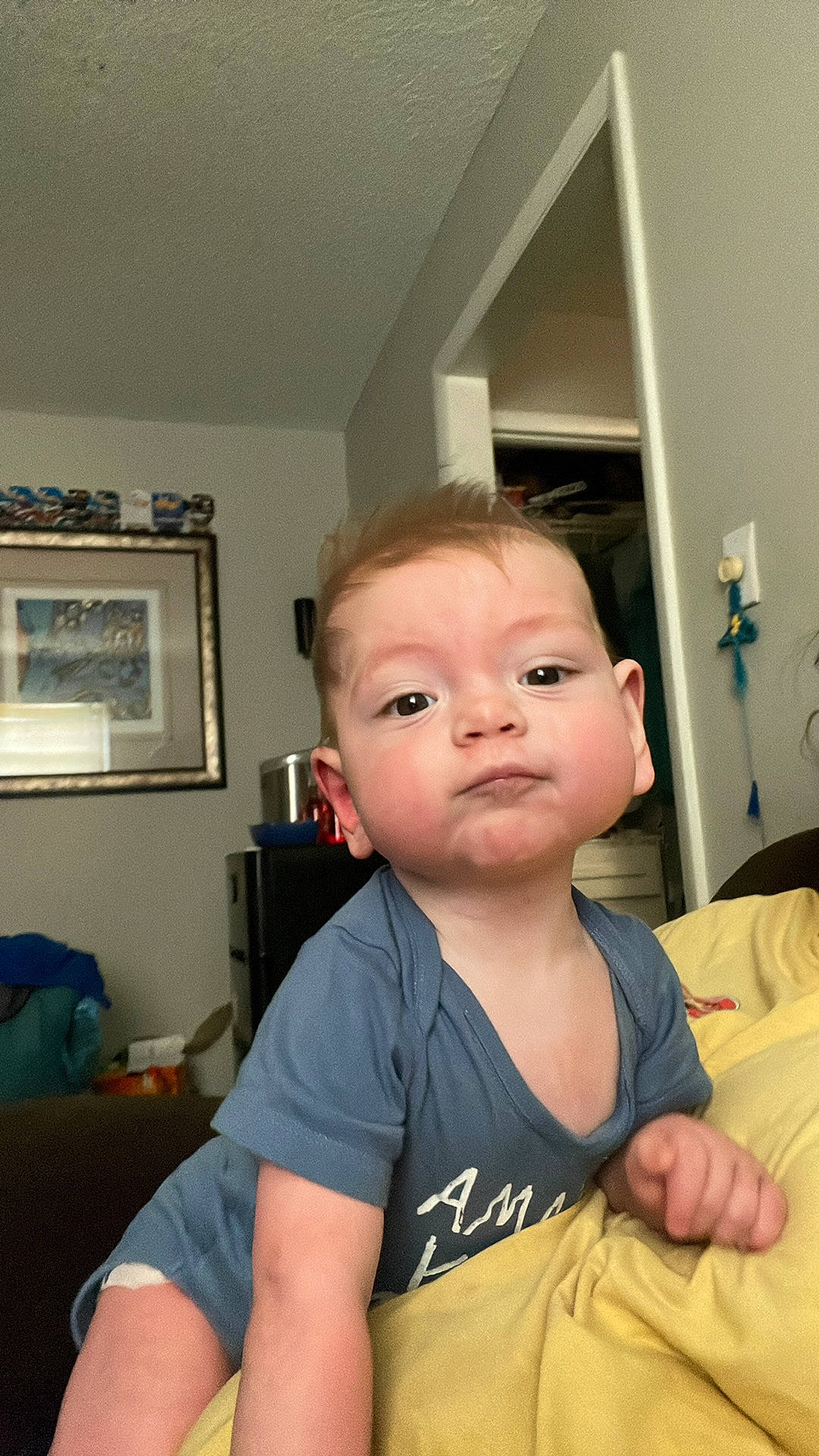 Brandon is registered to the contest to win money with this photo: abdomen, baby, baby_toddler_clothing, backpack, chair, cheek, chest, child, chin, comfort, elbow, eyelash, flooring, gesture, person, picture_frame, room, sitting, t_shirt, toddler