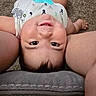 baby, infant, child, face, eyes, smiling, happy, lying_down, upside_down, portrait, indoor, carpet, cushion, adult, arms, diaper, teether, toy, closeup, photography