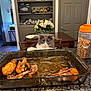 animal, baking_dish, cabinet, cat, cat_treats, chair, chicken_drumsticks, counter, curious, door, flower_vase, flowers, food, gray_cat, indoor, kitchen, pet, shoes, table, white_cat