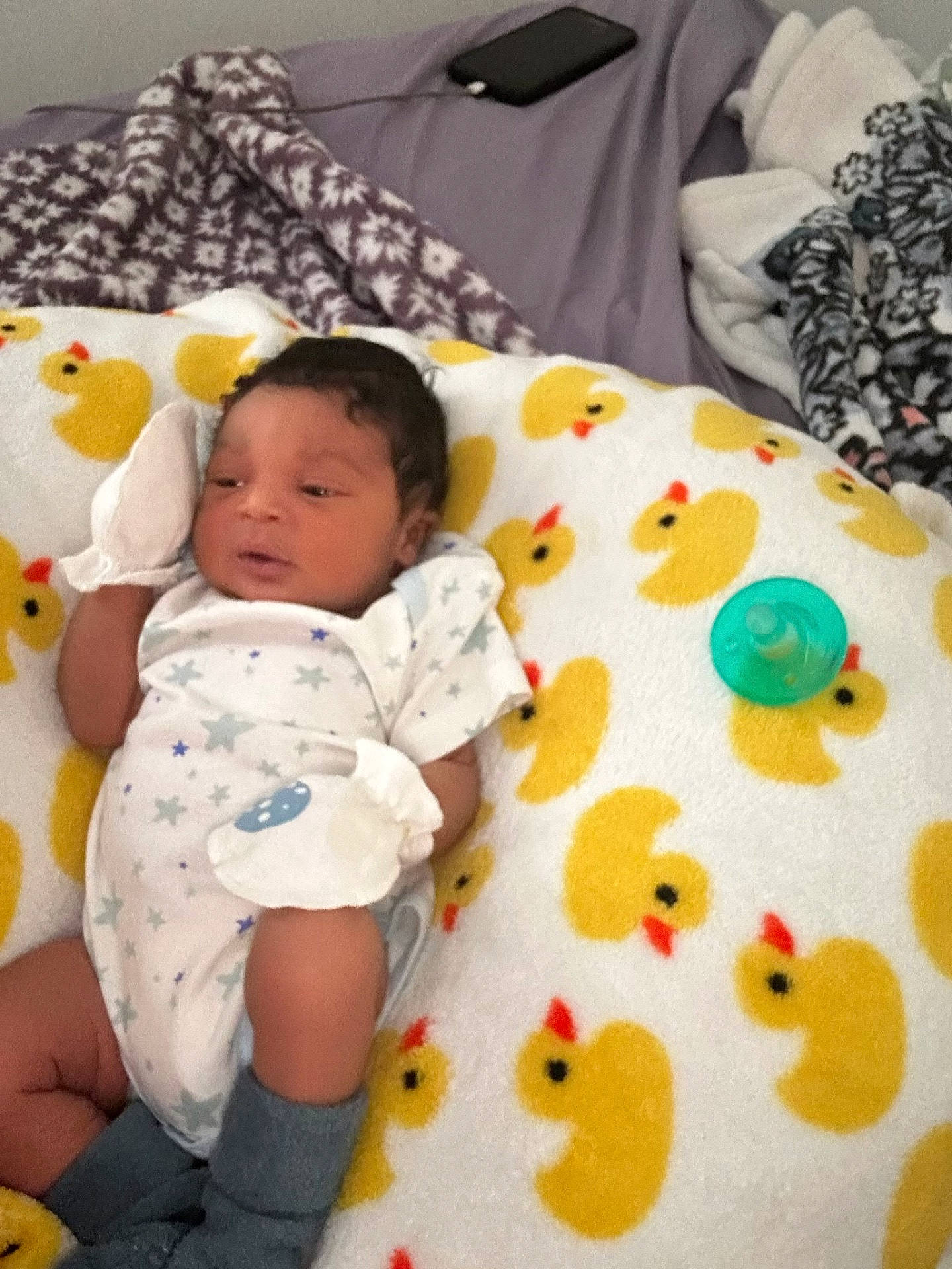 Matthew is registered to the contest to win money with this photo: baby, bed, bedroom, blanket, cushion, electronics, face, furniture, head, homedecor, indoors, mobilephone, newborn, person, phone, photography, portrait, quilt, room, toy