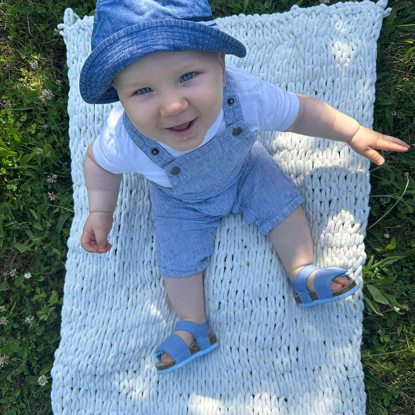 Maëlo participe au concours pour gagner de l'argent avec cette photo : baby, blue_hat, blue_overalls, child, cute, fun, grass, greenery, happy, infant, knitted_blanket, nature, outdoor, playful, portrait, sandals, sitting, smiling, summer, sunlight