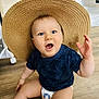 baby, child, straw_hat, blue_eyes, diaper, sitting, wooden_floor, indoor, cute, happy, toddler, hand_raised, expression, clothing, flooring, person, infant, headwear, smiling, casual