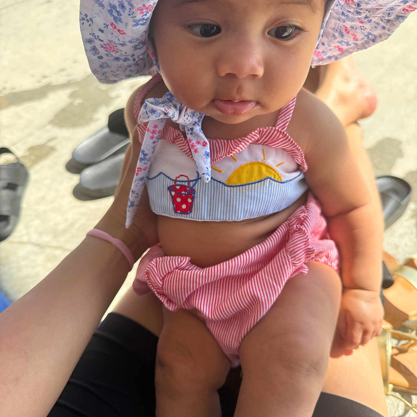 Kanaleia joined the competition — help win amazing prizes! arms, baby, child, closeup, curious_expression, floral_pattern, footwear, hand, hat, infant, legs, outdoor, person, sitting, skin, striped_clothing, summer, sun_hat, sunlight, swimsuit