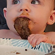 Daniel joined the competition — help win amazing prizes! baby, child, chocolate, closeup, curious, cute, eating, expression, face, food, hand, high_chair, holding, indoor, messy, mouth, person, plate, seat, young