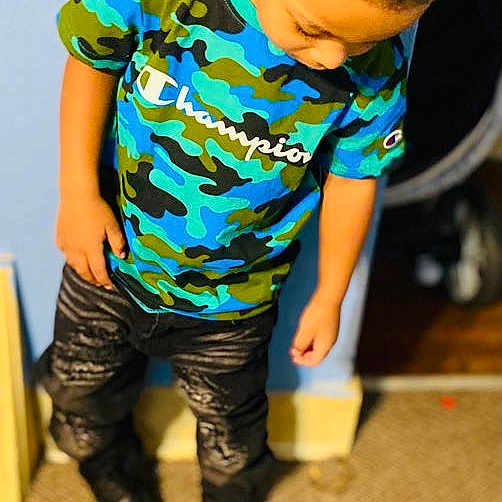 Deshawn joined the competition — help win amazing prizes! boot, child, denim, electric_blue, flooring, fun, human_leg, knee, leisure, pattern, personal_protective_equipment, play, sitting, sleeve, sportswear, t_shirt, thigh, tire, toddler, waist