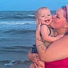 child, toddler, woman, kiss, beach, ocean, water, sky, smile, happy, tattoo, purple_hair, holding, summer, vacation, family, affection, outdoor, shore, waves