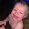 baby, child, smiling, happy, indoor, television, blue_light, skin, face, tooth, hand, arm, wood_floor, couch, person, closeup, expression, infant, cute, joy