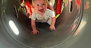 Emerson is registered to the contest to win money with this photo: baby, child, playground, tunnel, crawling, smiling, happy, person, outdoor, fun, joy, play, curious, hand, finger, clothing, light, reflection, face, toy