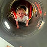baby, child, playground, tunnel, crawling, smiling, happy, person, outdoor, fun, joy, play, curious, hand, finger, clothing, light, reflection, face, toy