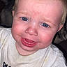baby, blonde_hair, blue_eyes, child, closeup, colorful_text, cute, emotion, expression, face, indoor, mouth_open, person, portrait, skin, stain, sweatshirt, toddler, white_shirt, young_child