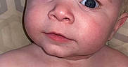 Emerson is registered to the contest to win money with this photo: baby, face, blue_eyes, expression, skin, blanket, pattern, shirtless, close_up, infant, child, portrait, cute, confused, human, lying_down, indoors, soft_light, pink_skin, young
