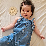 Leah joined the competition — help win amazing prizes! baby, smiling, denim, clothing, infant, hair_clip, plaque, milestone, bed, soft, cute, portrait, child, happy, lying_down, fabric, button, cherry_pattern, skin, indoor