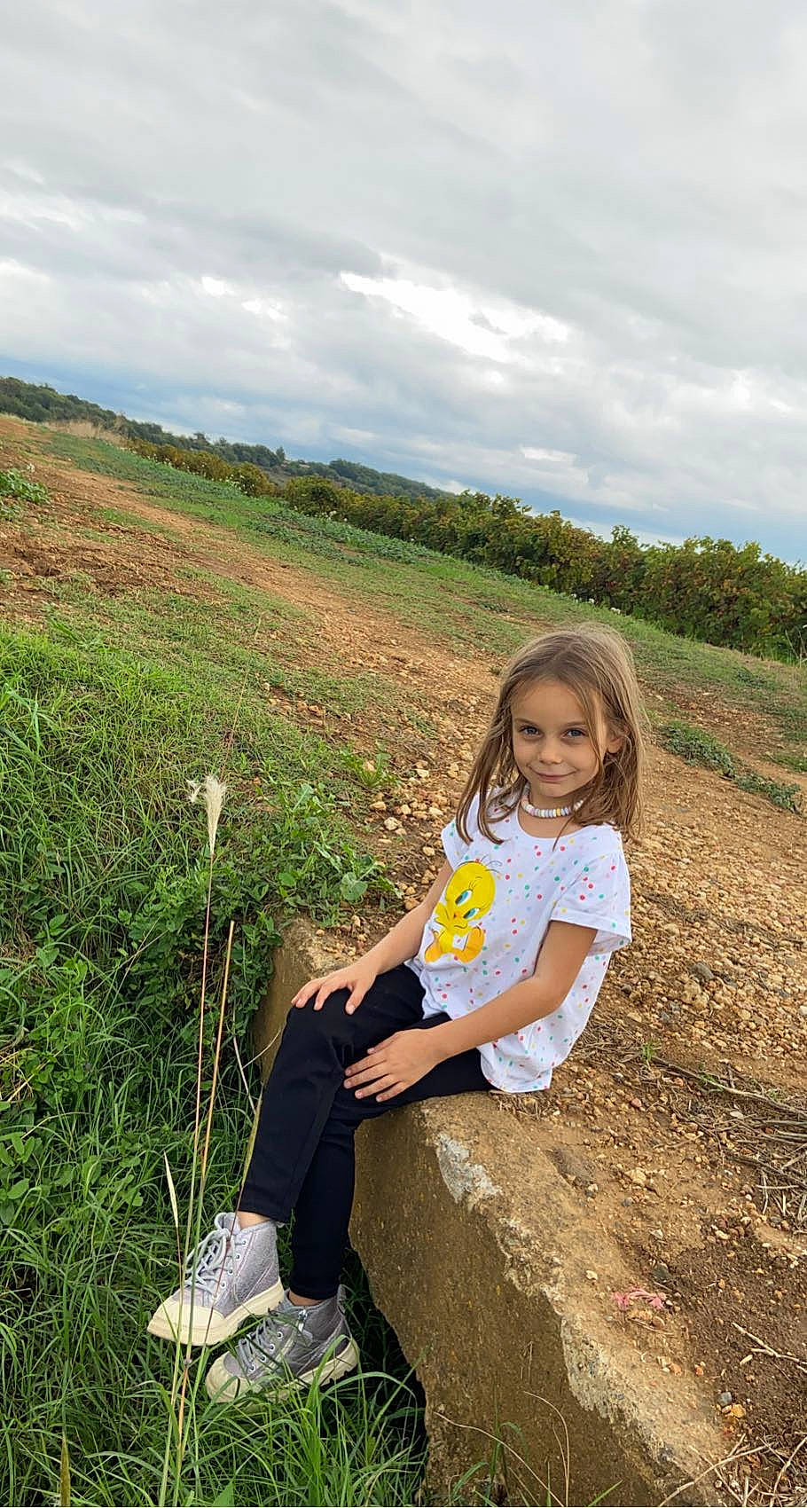 Emy participe au concours pour gagner de l'argent avec cette photo : agriculture, cloud, field, fun, grass, grassland, happy, hill, joy, landscape, leisure, people_in_nature, person, plant, prairie, recreation, sitting, sky, soil, toddler