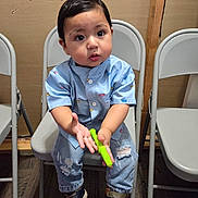 Aziel joined the competition — help win amazing prizes! toddler, child, boy, blue_shirt, ripped_jeans, sneakers, folding_chair, indoor, toy, curious, seated, wood_floor, casual_clothing, short_hair, expression, furniture, background_wall, hand_gesture, young_child, playful