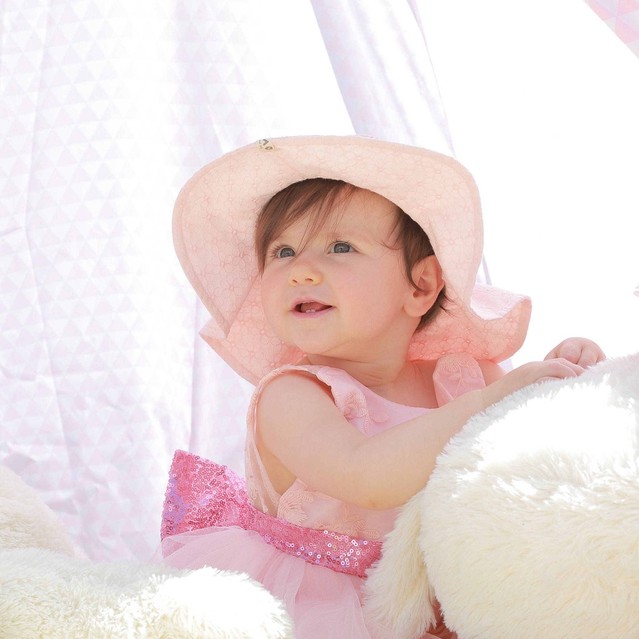 Léona participe au concours pour gagner de l'argent avec cette photo : baby, baby_toddler_clothing, child, comfort, embellishment, event, fashion_accessory, flash_photography, hair_accessory, happy, headgear, pattern, peach, person, pink, portrait_photography, smile, sun_hat, sweetness, textile