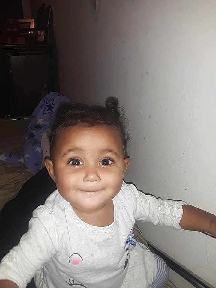 Amazin Miller joined the competition — help win amazing prizes! toddler, child, smiling, indoor, white_clothing, blanket, star_pattern, face, happy, cute, person, portrait, young_child, baby, hand, wall, bed, cozy, expression, curly_hair