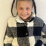 black_and_white, braids, casual, checkered, child, clothing, cute, fashion, fleece, girl, happy, indoor, jacket, person, pigtails, portrait, smile, standing, warm, young