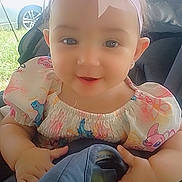 Vitalia a rejoint le concours — aidez-le/la à gagner de superbes lots ! baby, child, girl, stroller, headband, bow, pink, dress, cartoon_print, smiling, outdoor, daylight, cute, happy, infant, person, seat, hands, face, portrait