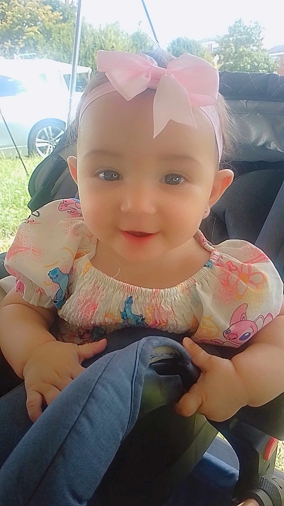 Vitalia a rejoint le concours — aidez-le/la à gagner de superbes lots ! baby, child, girl, stroller, headband, bow, pink, dress, cartoon_print, smiling, outdoor, daylight, cute, happy, infant, person, seat, hands, face, portrait