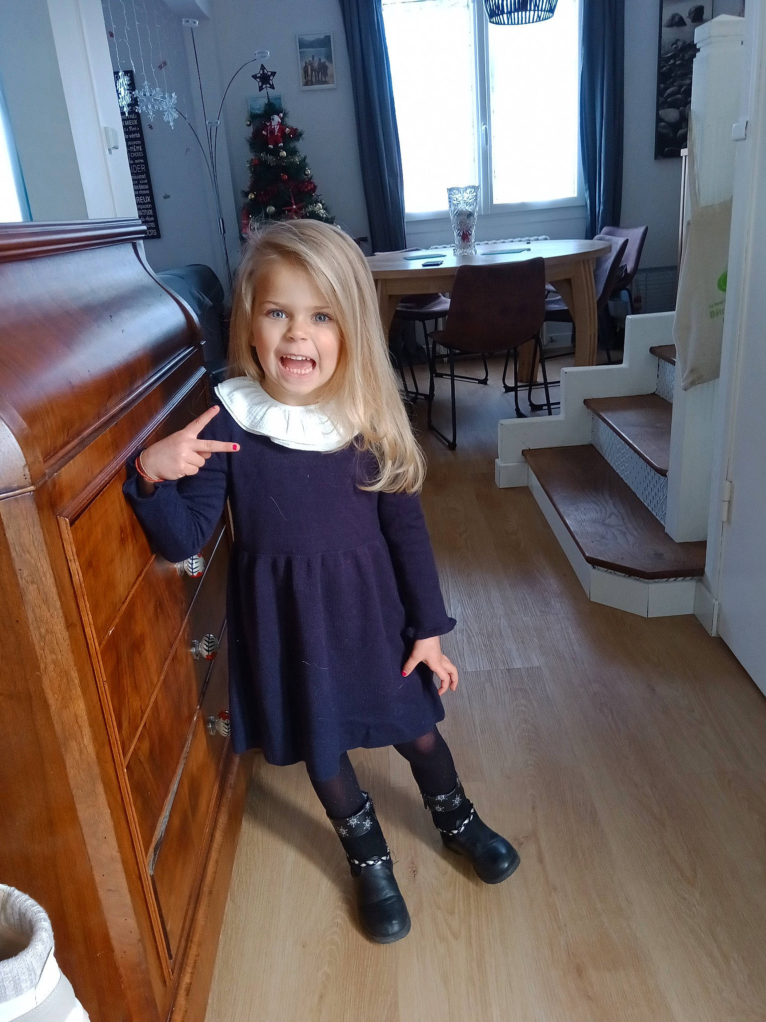 April participe au concours pour gagner de l'argent avec cette photo : blond, cabinetry, chair, curtain, floor, flooring, fun, hardwood, joy, long_hair, person, purple, room, shoulder, sitting, smile, standing, toddler, varnish, window