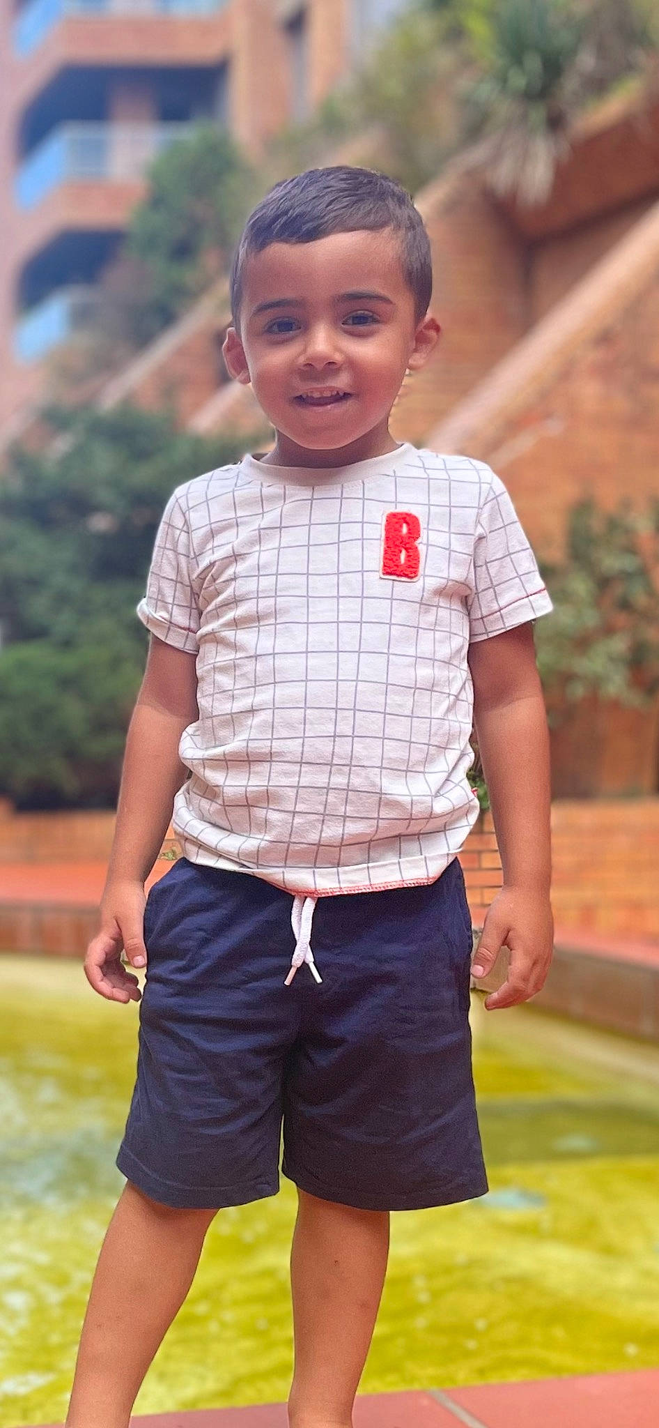 Nael a rejoint le concours — aidez-le/la à gagner de superbes lots ! active_shorts, bermuda_shorts, board_short, cool, electric_blue, fun, grass, happy, leisure, person, photograph, plaid, plant, shorts, sleeve, smile, sportswear, summer, t_shirt, toddler