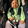 Noé participe au concours pour gagner de l'argent avec cette photo : baby, child, car_seat, harness, green_hoodie, gray_pants, smiling, happy, face, hand, safety, seatbelt, infant, cute, indoors, person, clothing, portrait, closeup, seat