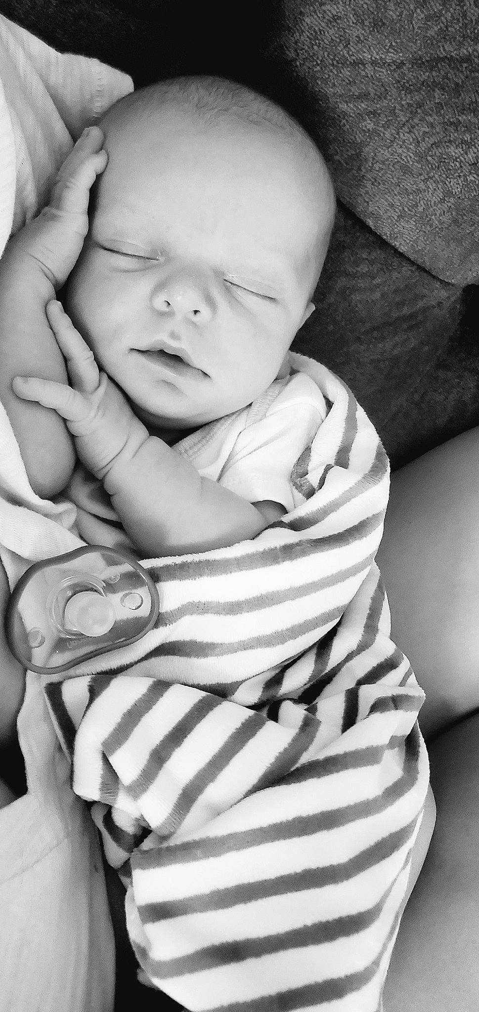 Lucian is registered to the contest to win money with this photo: baby, baby_toddler_clothing, black_and_white, cheek, comfort, face, finger, flash_photography, gesture, happy, lip, monochrome, neck, person, photograph, skin, sleeve, standing, style, toddler