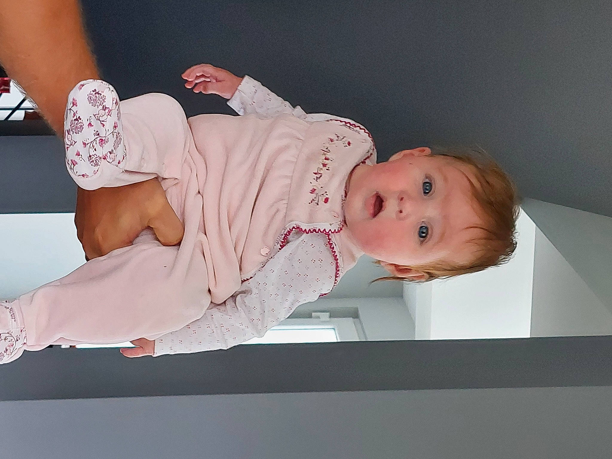 Lou a rejoint le concours — aidez-le/la à gagner de superbes lots ! baby, baby_products, baby_toddler_clothing, child, comfort, elbow, facial_expression, flooring, foot, human_leg, knee, person, pink, room, sitting, skin, sleeve, smile, surprise, thigh