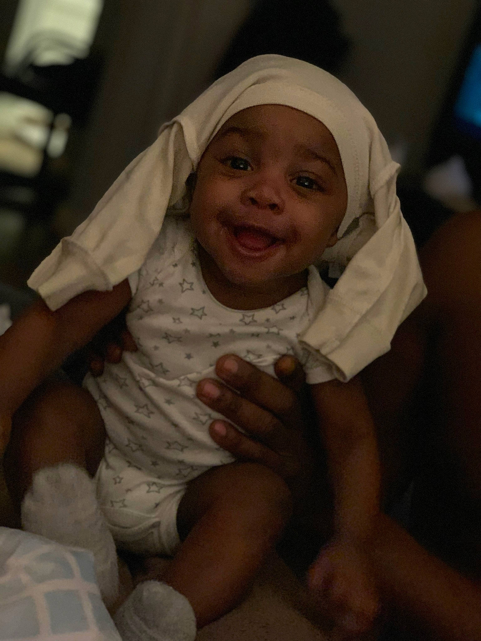 Montez is registered to the contest to win money with this photo: baby, baby_products, baby_toddler_clothing, cheek, child, comfort, finger, fun, gesture, happy, headwear, human_body, laugh, mouth, person, sitting, skin, sleeve, smile, thumb