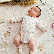 ëlyah a rejoint le concours — aidez-le/la à gagner de superbes lots ! adorable, baby, cozy, cute, decor, dried_flowers, fluffy_rug, indoors, infant, light_colors, lying_down, newborn, onesie, peaceful, portrait, small_feet, small_hands, socks, soft_texture, wooden_stars